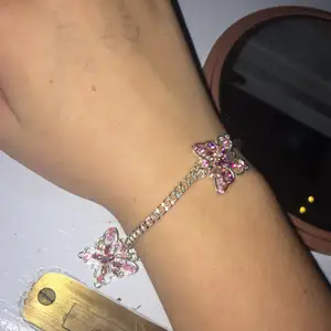 Silvrigt armband med rosa fjärilsberlocker. Kedja på 22cm. Säljs pga för stort. Kostade 49kr. Inte använt å inget slitage. 
