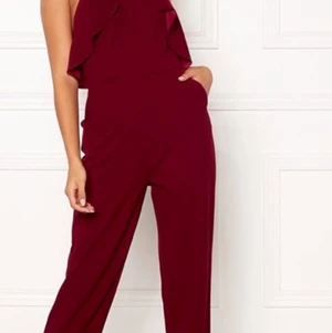 Vinröd jumpsuit  - Säljer denna vinröda dress som tyvärr är för stor för mig. Den är bar i ryggen med knäppe bakom nacken och är storlek 36. Använd en gång. 