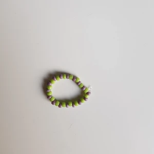 Lila och grön pärlring - Lila och grön pärlring som är såklart också handgjord. Precis som alla andra smycke går det fint att önska vilka färger man vill ha eller inte vill ha med.