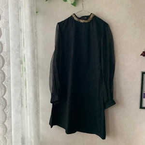 A-line 60-tal vintage klänning  - Svart finklänning i a-line modell med mesh armar, guld detaljer på kragen och ser ut som 60-tals modd stil. Köpt i Paris och tyvärr har jag vuxit ur den