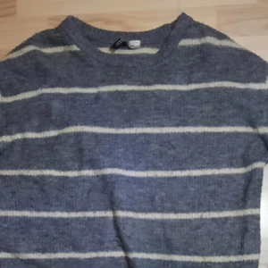 Randig tröja - Här säljs det en stickad randig grå tröja! Bra till både sommaren och vintern.