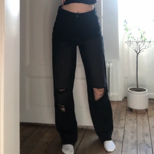 Långa vida svarta byxor med hål i knäna  - Snygga jeans köpta för boohoo! Köpte för ett år sedan och har slutat använda de tyvärr. Jag är 178 cm lång. Frakten ingår i priset🖤