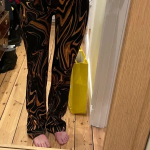 Färgglada utsvängda byxor  - Byxor köpa på mango, använda 1 gång, utsvängda med dragkedja på sidan 