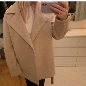 Kort kappa beige - Lägger ut igen pga oseriös köpare! Nypris 799kr. Den är i ullblandning så den är i så kallad premium kvalitet. storlek 36. Från nakd i en fin beige färg. Den är i använt men fint skick därav billigt pris! Frakt ingår inte i priset, köpare får betala frakt, kan mötas upp i Alvik🥰