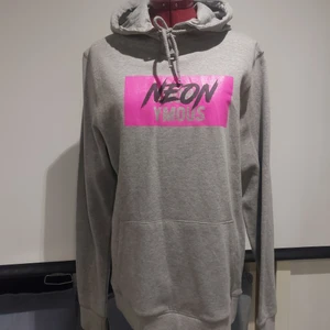 Grå hoodie - Säljer min gråa hoodie med neon rosa text.💕 En av favoriterna men har insett att jag har 3 st liknande så den här får någon annan ta hand om nu🥰. Den är köpt på herr avdelningen och är i storlek M. Fint skick knappt använd. Orginalpris: 300 kr💕