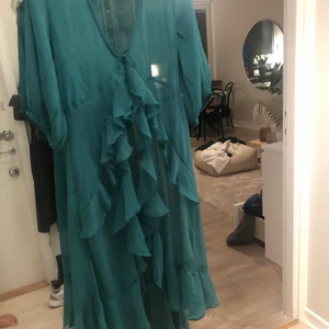 Grön kimono klänning transparent  - Grön kimono med volanger som är sååå fin men kommer tyvärr aldrig till användning! Endast använd en gång.Köparen står för frakten 