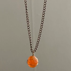 karnelian kristall halsband - äkta karnelian kristall men metall tråd runt om och silver kedja. kristallen är bra för att balansera kroppens energi nivåer, hjälper med stress och är en läkande kristall. 