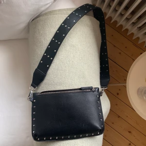 Svart väska från Carin Wester. - Axelremsväska med ett matchande band (som går att ta av). Små vita märken men annars i bra skick. 🧡