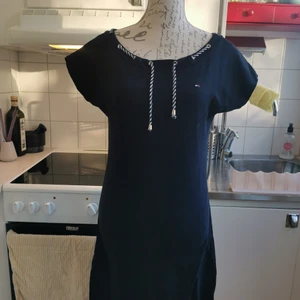 Mörkblå klänning från Tommy Hilfiger, Medium - Stilren mörkblå klänning med båthals från Tommy Hilfiger. Klänningen passar 36-38, dvs, medium.   Det går bra att både hämta upp den på Södermalm i Stockholm eller skickas med spårbar frakt. Jag ansvarar ej för postens slarv men föredrar spårbar frakt för bådas skull, lycka till!