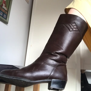 Bruna läderstövlar - Bruna vadlånga stövlar i äkta läder (från second hand) som är lite fodrade och därför väldigt sköna! Dragkedja och liten klack på 3 cm. Skorna är i begagnat skick men fortfarande snygga och fräscha, klackens undersida är borta så därav priset! frakt 66kr💕