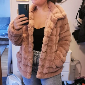 Rosa fake pälsjacka stl. M - Jackan är knappt använd så är i väldigt fint skick. Säljer för att den inte passar min stil. En del av en knapp saknas för att stänga jackan men övriga knappar finns så den går att stänga ändå. Jackan är ganska stor i storleken så passar även L. Köparen står för frakten. 