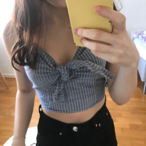 Ljusblå topp - Säljer denna toppen då den tyvärr är för stor för mig nu. Det syns inte så bra på bilderna men toppen är ljusblå, med vita ränder. Har en knytning vid brösten som man kan justera. 