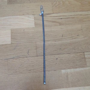 Dragkedja halsband - Ett halsband som ser ut som en dragkedja, man kan dra upp dragkedjan hela vägen upp och hela vägen ner. Fint skick, använd en gång och testad. Kommer från Glitter och man kan justera storleken om man vill. (Köparen står för frakten)