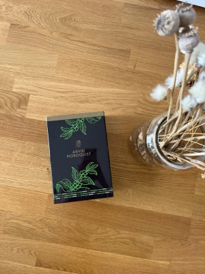 Arvid Nordquist kaffe låda - Snygg låda med Arvid Nordquist kaffe, svart kartong med gröna växtmotiv och silverdetaljer. Perfekt som gåva till kaffeälskaren eller att ha hemma för speciella tillfällen.