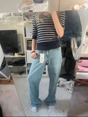 Ljusblåa vida jeans  - Säljer ett par ljusblå jeans med vida ben och medelhög midja. Köptes på Gina Tricot men de är tyvärr för små. Helt nya. Jag accepterar alla bud!