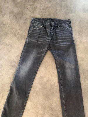 Grå slim fit jeans från dsquared2 - Snygga grå jeans i slim fit-modell med diskreta slitningar och klassisk femficksdesign. Jeansen har dragkedjegylf och bälteshällor. Perfekta för en avslappnad och trendig look från dsquared2