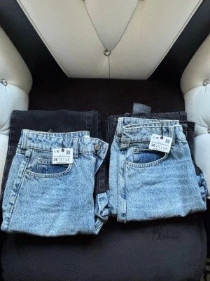 Tvåfärgade jeans med kontrastben - Säljer ett par unika tvåfärgade jeans med ljusblå denim upptill och svart denim nedtill. Jeansen har klassisk femficksdesign, raka ben och hög midja. Perfekta för dig som vill sticka ut med en cool och trendig look. Köpta i Zara med etikett på helt oanvända . 