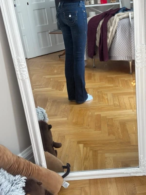 Mörkblå bootcut jeans från True Religion - Säljer ett par mörkblå bootcut jeans från True Religion. Modell: Becca. Jeansen är mid waist och har utsvängda ben, dem ser på gränsen till skinny ut men det är också för att de är för korta för mig.🌸
