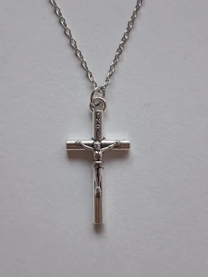 Silverfärgat korshalsband med Jesus - Snyggt halsband med ett silverfärgat kors och krucifix. Korset har detaljerade inskriptioner och hänger på en tunn kedja. Perfekt för dig som gillar klassiska och stilrena smycken med religiös touch.