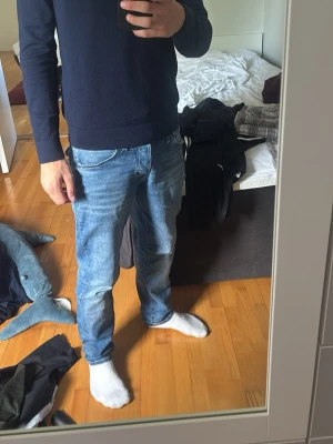 Mörkblå rundhalsad stickad tröja - Mörkblå stickad tröja med rund hals och långa ärmar. Tröjan har en enkel och stilren design med rak passform. Materialet ser mjukt och bekvämt ut, perfekt att bära över en t-shirt eller skjorta. Priset går o diskutera via snabb affär