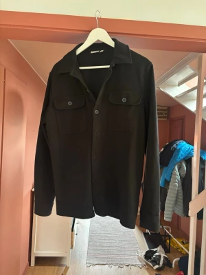 Svart overshirt med knappar  - Stilren svart overshirt från only sons med klassisk krage, knappar framme och riktigt snygg med bara en t shirt eller en tjocktröjan under.