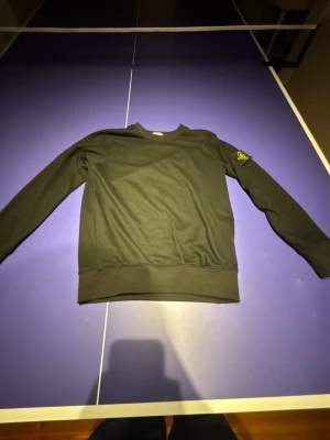Sweatshirt Stone Island Classic Crewneck ⚫ - Black Stone Island crewneck sweatshirt crafted from soft cotton, featuring the iconic detachable compass badge on the left sleeve. This versatile piece offers comfort and a distinctive style, perfect for casual wear.  ⭐️ Condition : 8/10 (Very lightly used, no visible flaws) 🎨 Color : Black 📦 Fast and careful shipping.