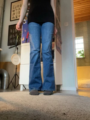 Blå bootcut jeans!! - Säljer ett par klassiska blå bootcut jeans med medel midja och utsvängda ben. Jeansen har en tidlös tvätt och sitter snyggt över höfterna. Perfekta för dig som gillar retrovibbar och vill ha ett par jeans som sticker ut lite extra. Kmr inte till användning och är för stora men är i toppen skick!!!❤️❤️