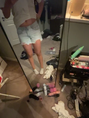 Ljusblå jeansshorts med rå kant - Säljer ett par ljusblå jeansshorts med rå, fransig kant nertill. Shortsen har klassisk femficksdesign och är högmidjade för en snygg passform. Perfekta till sommaren och lätta att matcha med olika toppar.