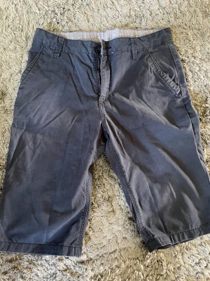 Mörkblå shorts från H&M - Snygga mörkblå shorts från H&M med klassisk passform och fickor på sidorna. Tillverkade i mjuk bomull och perfekta för varma dagar. Stängs med dragkedja och knapp framtill. Passar till det mesta i garderoben.