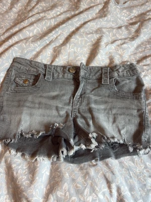 Lågmidjade jeansshorts  - Fina gråa lågmidjade jeansshorts, passar bra till många toppar på sommaren!! Knapp detaljer på fickorna. Köpte på plick men aldrig använda av mig💗 skriv om frågor🫶🏼 strl 158 men passar XS