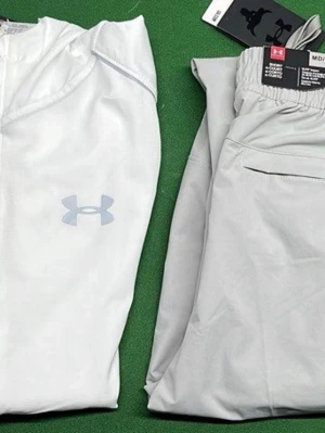 Under Armour träningsset hoodie & byxor - Säljer två träningsset från Under Armour med matchande hoodies och byxor. Ena setet är ljusgrått och det andra mörkgrått. Båda har dragkedja på hoodien, elastisk midja på byxorna och tydlig logga på bröstet och benet. Perfekt för gymmet eller löprundan.