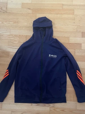 Boss zip hoodie (replika) - Mörkblå Hugo boss hoodie med orange ränder. (Replika) köpt på blocket för ca 400kr