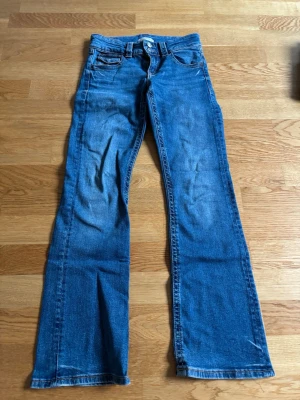 Blåa bootcut jeans med låg midja - Fina lite mer mörkare blåa bootcut jeans med låg midja från gina tricot young!