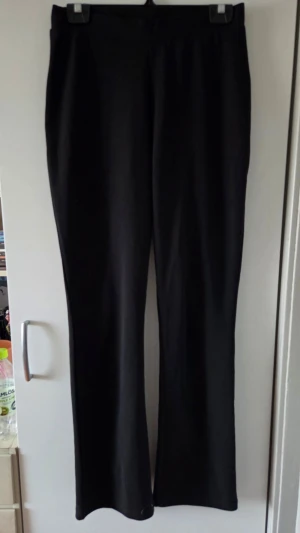 Svarta bootcut leggings - Säljer ett par svarta leggings med bootcut-modell. De har hög midja och är tillverkade i ett stretchigt material som sitter bekvämt. Perfekta för dig som gillar en enkel och stilren look med lite vidare ben.
