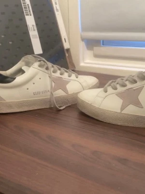 Golden goose  - Jag säljer nu ett par vita sneakers från golden goose. De har använt väldigt sparsamt men nu är ändå lite skitiga. Man ser på andra bilden att de är sparsamt använda då sulan knappt sliten. Det var rent innan jag skickas och observera original box kommer inte med. 