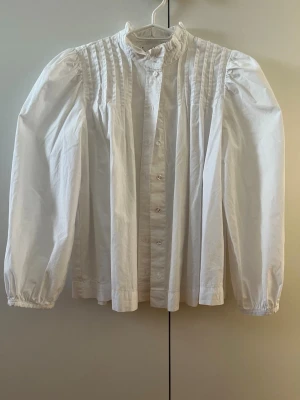 Blus Mango - Skjorta/Blus från Mango med puffärmar. Har några fläckar runt kragen från smink. 