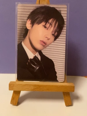 Desire: Unleash photocard K-pop Sunoo - Exklusiv photocard från K-pop albumet 'Desire: Unleash'. Kortet har en stilren design med svart kostym, vit skjorta och svarta handskar på framsidan. Baksidan är silverfärgad med texten 'DESIRE: UNLEASH'. Perfekt för samlare!