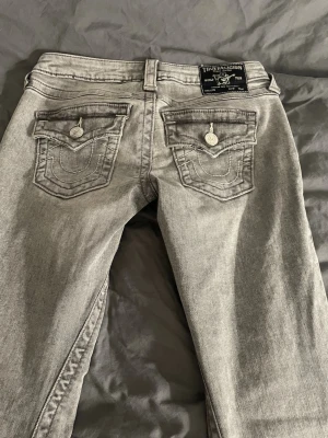 True Religion Jeans - Ljusgråa true religion jeans, strl 25, midjemått ca 36/37 cm (ngt stretchigt), midjehöjd ca 16 cm, innerbenslängd ca 80 cm, lite slitna längst ner på benen men inget man tänker på💓Säljs inte längre