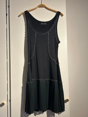Tiger of Sweden festklänning - Kort svart klänning med fina detaljer och plisserad kjol. Passar storlek 38/40