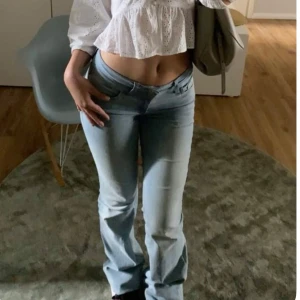 Ljusblå bootcut jeans mid waist midja - Snygga ljusblå jeans med bootcut och mid waist. Jeansen har klassisk femficksdesign och är tillverkade i mjukt denimtyg som sitter skönt. Perfekta för dig som gillar en avslappnad och trendig stil.