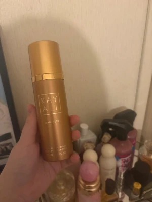 Kayali Vanilla 28 Body Spray - Kayali Vanilla 28 Body Spray i en lyxig guldfärgad flaska med elegant design. Doften har en varm och söt vaniljton och flaskan har en cylinderformad siluett med diskret logga framtill. Perfekt för dig som älskar exklusiva och trendiga parfymer. Endast testad 2 gågner