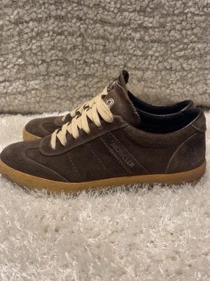Bruna Moncler sneakers i mocka - Säljer ett par unika moncler skor i storlek 41, mycket bra sick! Och ett bra pris på 1600kr ny prisetet ligger på 5999kr. Skriv gärna vid intresse och funderingar! 
