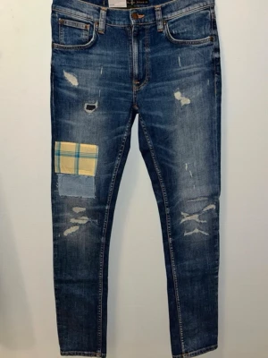 Blå jeans från Nudie med patch - Skriv för mer info!