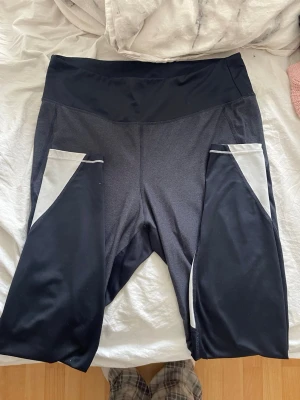 Svarta leggings med fickor - Snygga svarta leggings med hög midja och stora sidofickor i svart och grått. Tillverkade i stretchigt material som passar perfekt till träning eller chill. Fickorna har en cool kontrastdesign i ljusgrått. Inget synligt märke. Tveka inte på att fråga om du har några frågor!💕 svarar snabbt