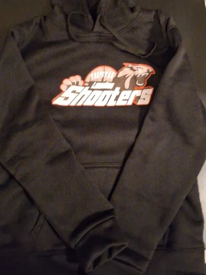 Svart hoodie Trapstar Shooters - Svart hoodie från Trapstar med trycket 'London Shooters' och ett pantermotiv på bröstet. Klassisk huva och känguruficka framtill. Tillverkad i mjukt material som passar perfekt för en chill och avslappnad stil.