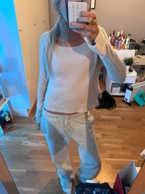 Vit/beige ribbad långärmad tröja - Säljer en vit/beige långärmad tröja med ribbad struktur och rund hals. Tröjan är croppad och har en avslappnad passform, perfekt för en chill look💕