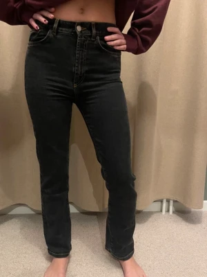 Jeanerica Black Jeans - Svarta jeans med hög midja och raka ben. Jeansen har klassisk femficksmodell och stängs med knapp och dragkedja. Materialet är denim och lite lite stretch. Modell EW004 från Jeanerica. Storlek 26/32. Något stor i storleken, skulle säga att den passar 27 och 28 också!