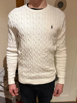 VIT RALPH LAUREN TRÖJA - Säljer en vit ralph lauren tröja som legat nästan oanvänd i 2 år. Riktigt schysst och skön tröja som fungerar bra själv eller i lager.                                                         (Modellen är 180cm, 72kg)