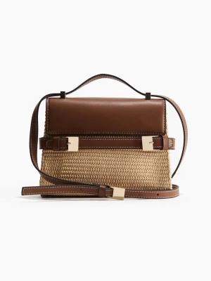 Brun och beige handväska i läder och rotting - Strukturerad hand-/axelväska i naturfärgat flätat material med bruna detaljer. Kompakt men stadig modell med lock och dekorativa spännen framtill. Avtagbar och justerbar axelrem. Perfekt storlek för vardagsbruk när du vill bära lätt men ordnat.🤍  Structured handbag/shoulder bag in natural woven material with brown details. Compact yet sturdy shape with a flap closure and decorative front buckles. Detachable and adjustable shoulder strap. Ideal size for everyday use when you want something light 