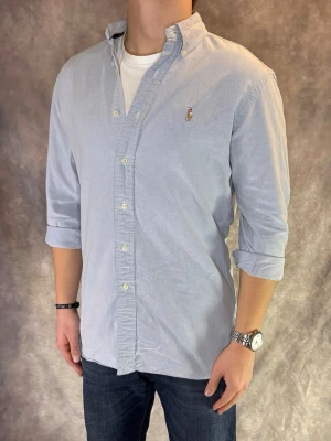 Ljusblå Ralph Lauren Skjorta - Stl M, Classic Fit - RIKTIGT FET RL SKJORTA I FÄRGEN LJUSBLÅ! 👔Mycket bra skick: 9/10, Smått sliten vid kragen, syns knappast vid användning, och en liten fläck ( se bilderna ) | Stl: M, Modellen är 175cm och väger ca 77kg, men passar lite längre | Hör av dig vid frågor // Galgen 🫡